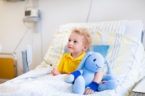 Young child in hospital bed waiting for a puzzle.