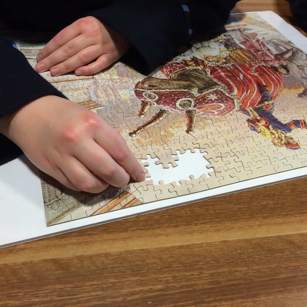 Hands assembling 1000-piece puzzle.