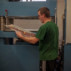Employee inspecting freshly pressed top quality custom photo jigsaw puzzle.