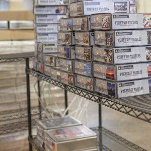 Variety of custom photo jigsaw puzzles on a shelf.